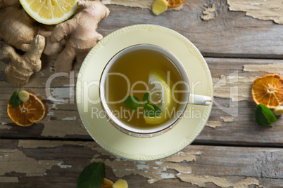 Directly above view of lemon and mint leaves in ginger tea on weathered table