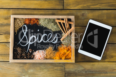 Various type of spices on slate and digital tablet