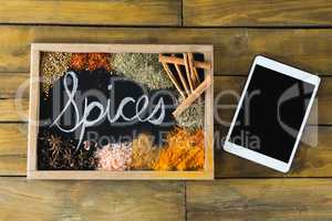 Various type of spices on slate and digital tablet