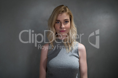 Portrait of beautiful woman standing against grey background