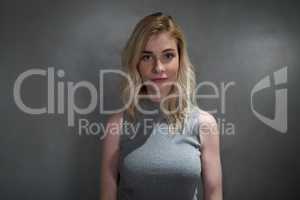 Portrait of beautiful woman standing against grey background