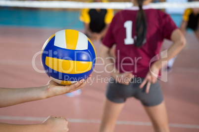 Female players playing volleyball in the court