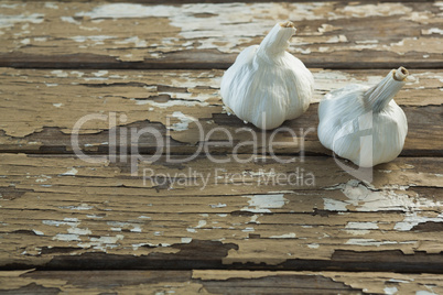 Two garlic bulbs on wooden table