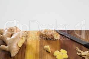 Close up of fresh chopped ginger and knife on wooden cutting board