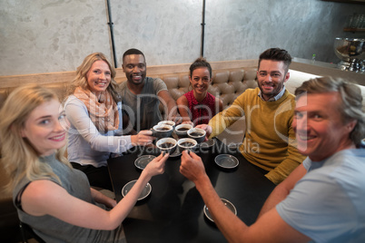Portrait of happy friends toasting coffee