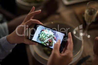 Woman taking photo of meal with mobile phone