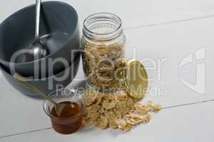 Flakes and bowl of honey on table