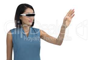 Female executive gesturing while using virtual reality headset
