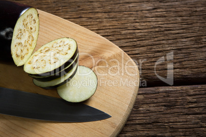 Sliced eggplant with knife on chopping board