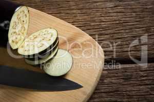 Sliced eggplant with knife on chopping board