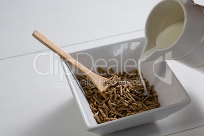 Pouring milk into bowl of cereal bran sticks