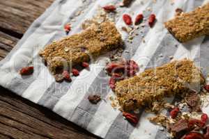 Granola bar and dried fruits on table cloth