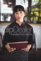Portrait of confident young waitress holding menu