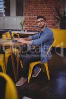 Portrait of handsome man wearing eyeglasses using laptop at coffee shop