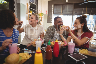 Young friends sharing food at coffee shop