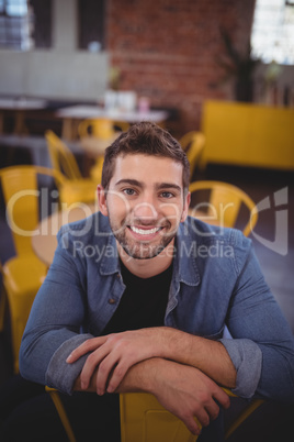 Portrait of smiling handsome man sitting on chair