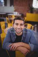 Portrait of smiling handsome man sitting on chair