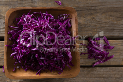 Chopped red cabbage in tray on wooden table