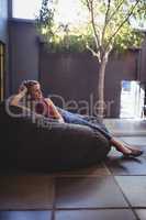 Full length of young woman relaxing on bean bag