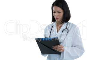 Female doctor writing prescription on clipboard