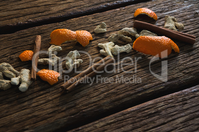 Cinnamon sticks, orange peel and dried ginger on a wooden table