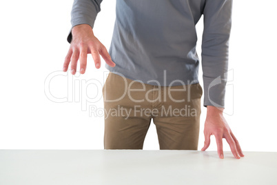 Mid section of businessman gesturing at table