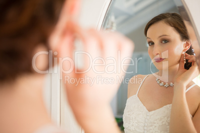 Beautiful bride in wedding dress looking into mirror
