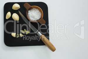 Chopped garlic with bowl of sea salt and knife