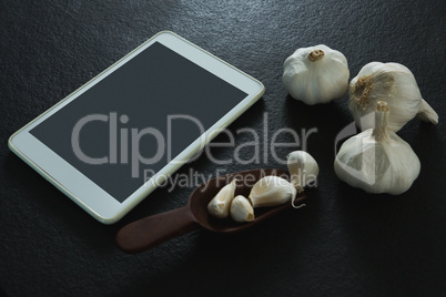 Garlic with digital tablet on black background