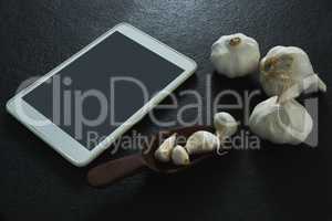 Garlic with digital tablet on black background