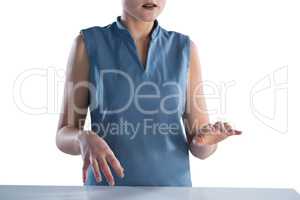 Mid section of businesswoman using imaginary screen at table