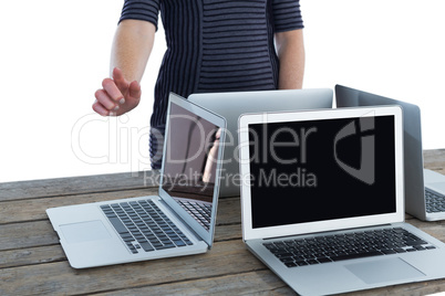 Mid section of businesswoman using interface by laptop computers on table