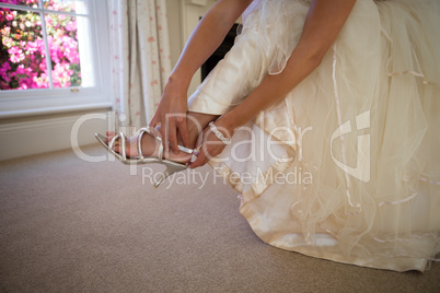 Low section of bride in weding dress wearing sandals
