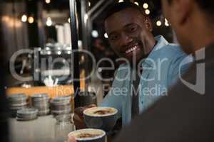 Happy man interacting while having coffee