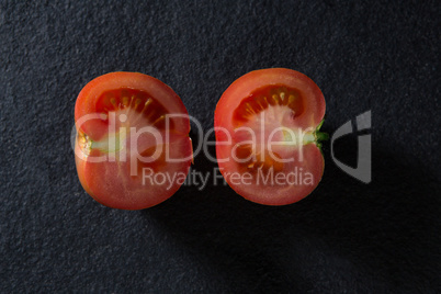 Halved tomato on black background