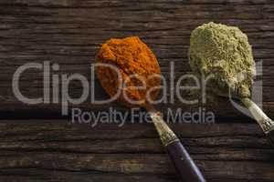 Red chili powder and coriander powder on a wooden table
