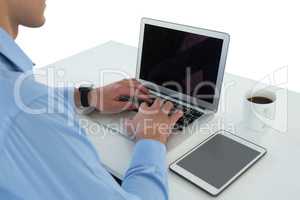 Side view of businessman using laptop at table