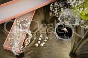 High angle view of bride jewelry on sofa