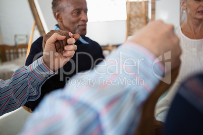 Senior male and female friends holding hands