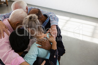 High angle view of senior male and female friends huddling