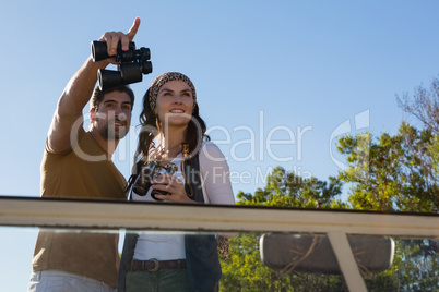 Man with woman pointing in off road vehicle