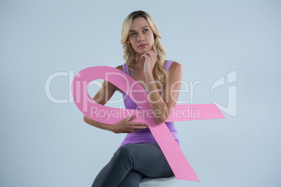 Thoughtful woman with Breast Cancer Awareness ribbon