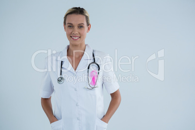 Portrait of smiling female doctor with Breast Cancer Awareness ribbon