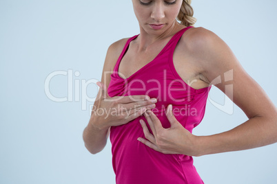 Young checking lumps while examining breast