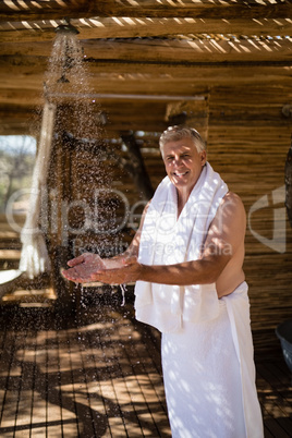 Man washing hands from shower in cottage during safari vacation