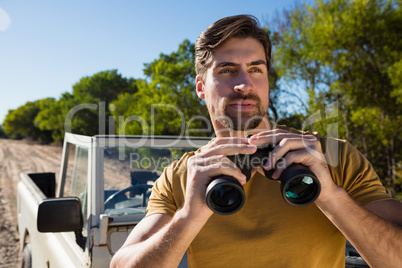 Young man holding binocular