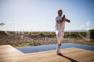 Man practicing yoga on wooden plank