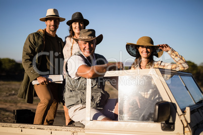 Portrait of happy friends enjoying in vehicle during safari vacation