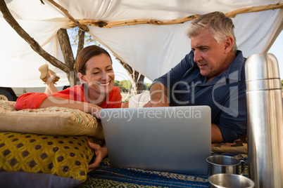 Couple looking at laptop in tent