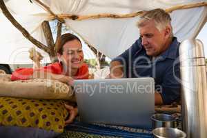 Couple looking at laptop in tent